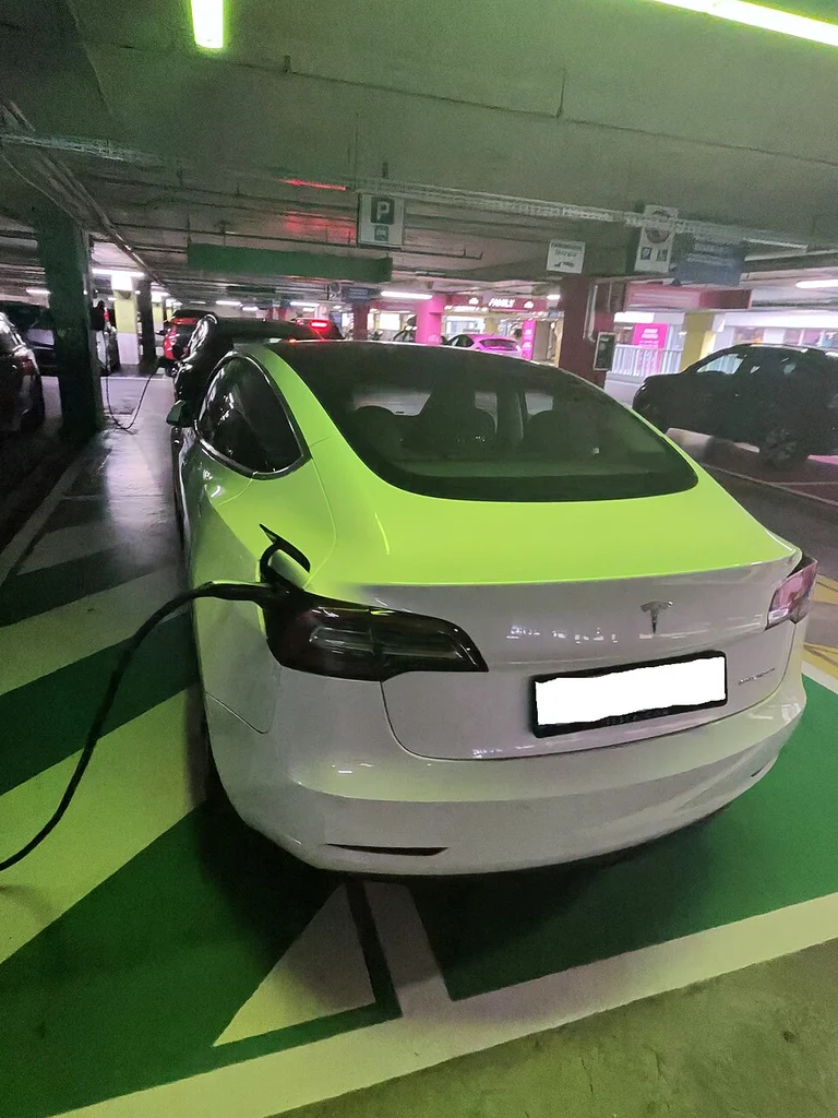 Tesla Model 3 charging at mall EV charging station showing commercial charging business opportunity